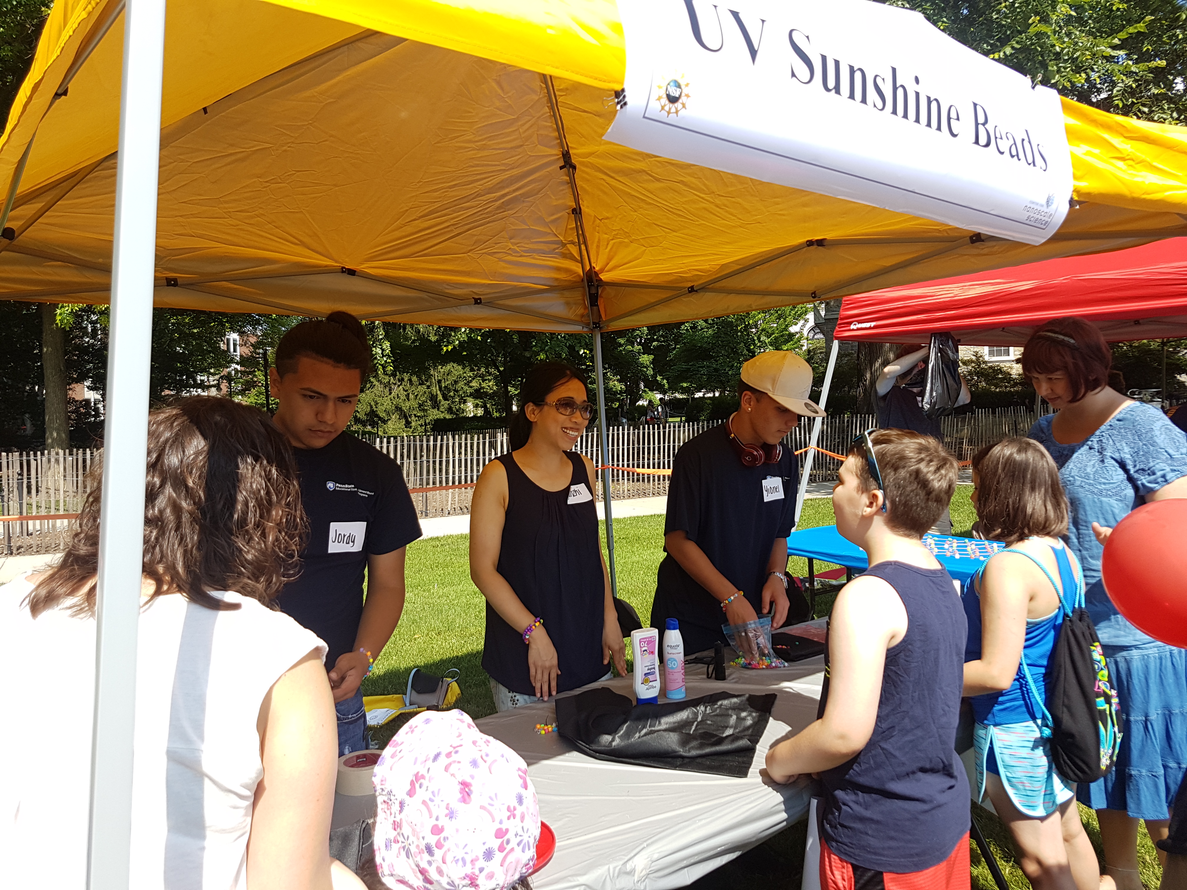 photo of grad students talking to high school students at outdoor event