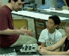Graduate Student Dave Fleming demonstrates how electronic ink works using the egg tray and ping pong balls. Teacher demonstrating procedure to student